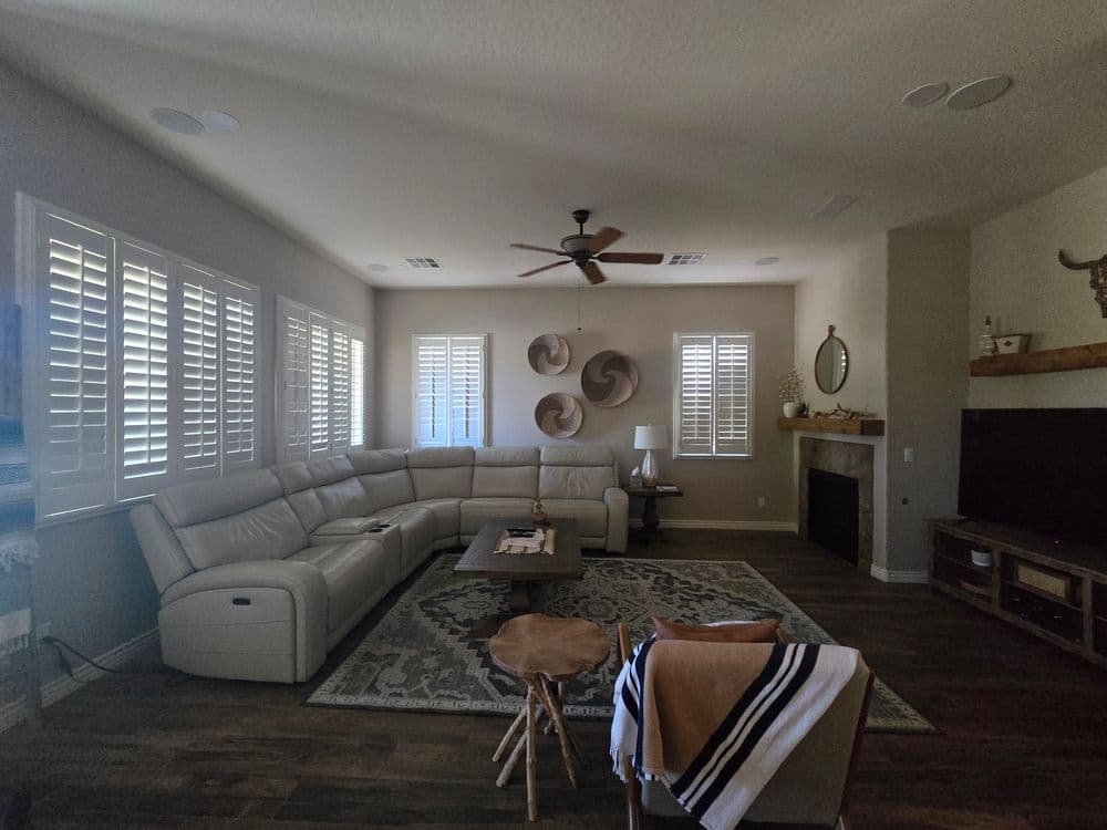 Spacious living room with white sectional sofa, decorative wall art, and modern decor.